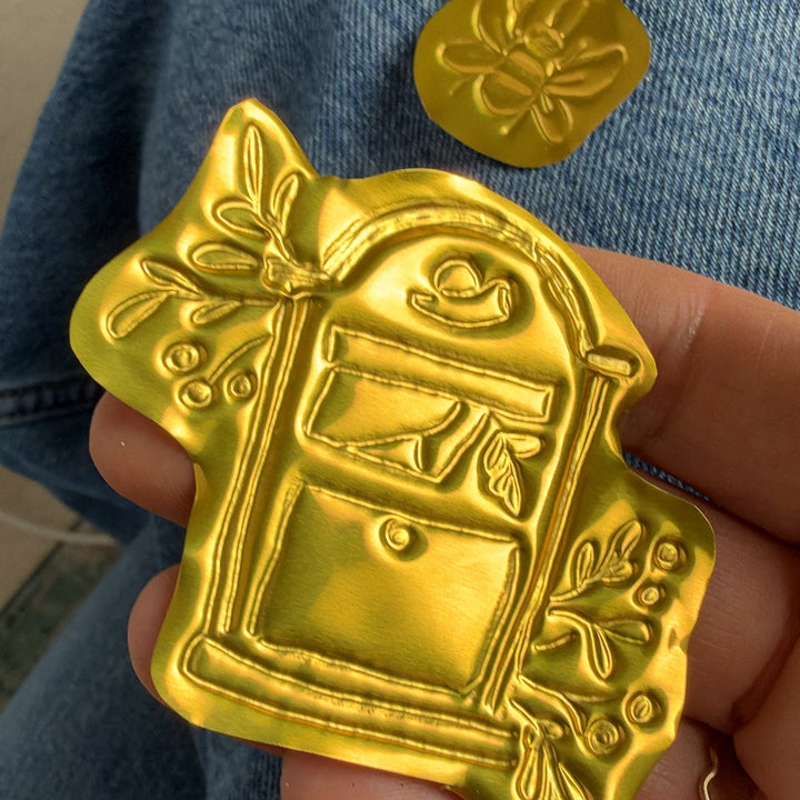 Geprägtes Motiv aus Prägefolie Gelbgold in der Hand